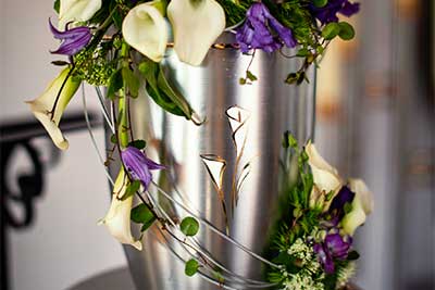 Urne mit Calla, Clematis, Bartnelke und Trachelium beschmückt